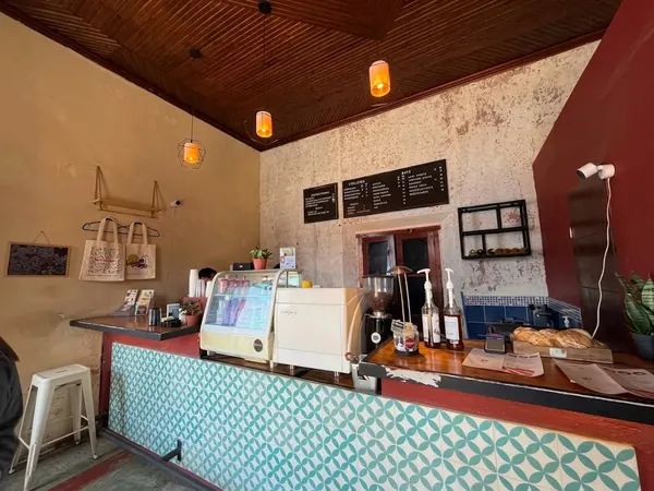 Barra del café con máquina de espresso, pizarras de menú y azulejos turquesa